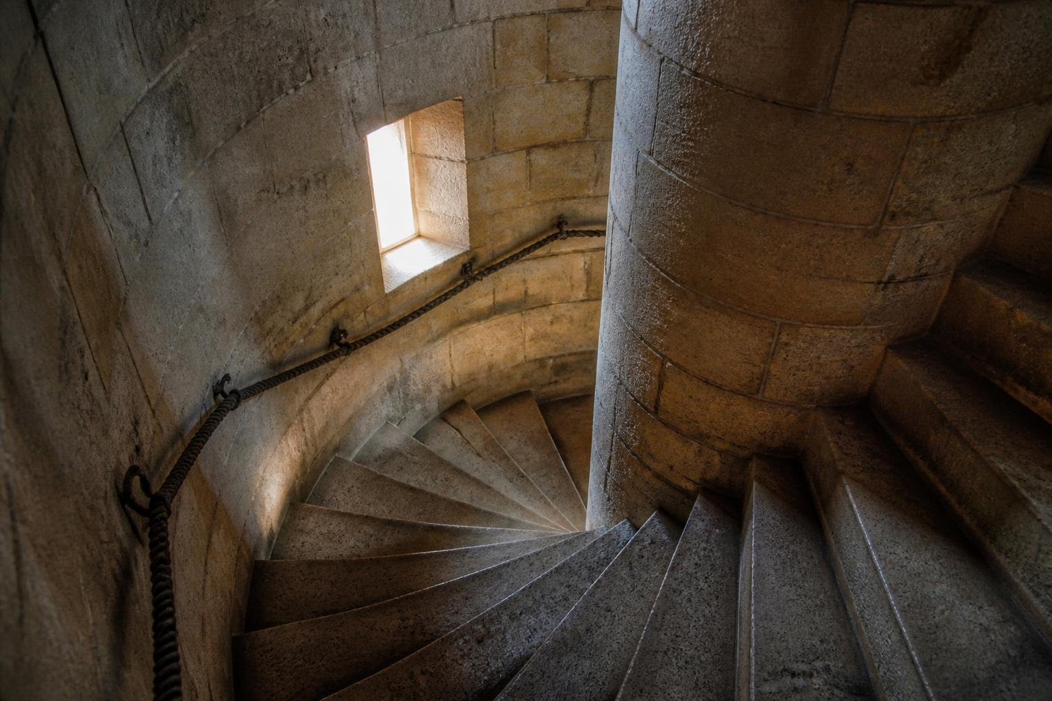 Escalier en spirale à l'intérieur d'une tour de phare, montrant la structure architecturale en pierre